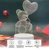 A 3D wireframe teddy bear holding a heart-shaped balloon, illuminated by a white light, set against a dark background with red Christmas ornaments. Produktbild-Vorschau