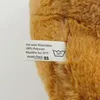A close-up of a teddy bear's fur with a care label attached. Anteprima dell’immagine prodotto
