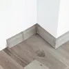 A corner of a room showing a floor and baseboard. Produktbild-Vorschau