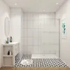 A modern bathroom with a walk-in shower, vanity, and patterned floor tiles. Produktbild-Vorschau