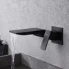 A black wall-mounted faucet with water flowing into a sink. Náhled obrázku produktu