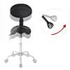 A black ergonomic saddle stool with a silver base and wheels, shown on a white background. A circular inset highlights the tilt feature with an arrow. Anteprima dell’immagine prodotto