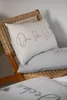 Two pillows are placed on a wicker chair, with a blanket in the foreground. Produktbild-Vorschau