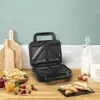 A sandwich maker on a kitchen counter with breakfast items. Podgląd zdjęcia produktu