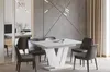 A modern dining room with a white high-gloss extendable dining table and four dark gray chairs. Produktbild-Vorschau