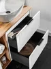A close-up view of a white bathroom vanity with two open drawers, revealing a sink and storage. Podgląd zdjęcia produktu