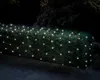 A hedge decorated with warm white LED lights at night. Produktbild-Vorschau