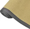 A close-up, rolled-up view of a sisal rug with a gray border. Voir les images du produit