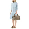 A woman stands against a white background, holding a duffel bag. Náhled obrázku produktu