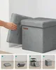 A hand is shown placing the lid on a grey fabric storage ottoman. Below are four sequential images demonstrating how to assemble the ottoman. Náhled obrázku produktu