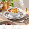 A table setting with a salad bowl, plates, cutlery, and a glass of water. Náhled obrázku produktu