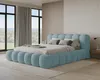 A modern bedroom with a large, plush blue bed as the centerpiece, featuring large windows with a view of greenery. Voir les images du produit