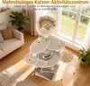 A multi-level cat tree is set up in a living room with a sofa and plants. Produktbild-Vorschau