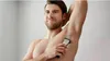 A man is shaving his armpit with an electric shaver. Podgląd zdjęcia produktu
