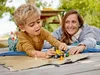 A mother and child playing with a toy construction truck on a wooden deck outdoors. Produktbild-Vorschau