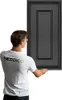 A man in a white t-shirt is holding a black wall panel. Podgląd zdjęcia produktu
