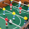 A close-up view of a foosball table with several player figures and a ball. Anteprima dell’immagine prodotto