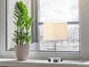 A table lamp and a potted plant on a windowsill. Náhled obrázku produktu