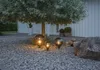 Outdoor decorative globe lights placed under a tree on a gravel surface. Produktbild-Vorschau