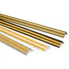 Several L-shaped corner profiles with yellow adhesive strips are arranged diagonally on a white background. Anteprima dell’immagine prodotto