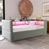 A modern bedroom with a light gray sofa bed featuring built-in LED lighting and storage. Produktbild-Vorschau