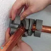 Hands are shown installing a pipe insulation fitting onto a copper pipe. Produktbild-Vorschau