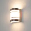 A modern silver wall lamp with a frosted glass diffuser, mounted on a light gray wall. Produktbild-Vorschau