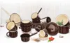 A collection of enamel cookware and mugs arranged on a white and light gray background. Anteprima dell’immagine prodotto