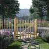 A wooden garden gate in a natural outdoor setting with trees and a hillside in the background. Náhľad obrázku produktu