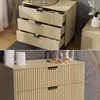 A collage of two images showing a wooden dresser with fluted drawers and black handles, decorated with vases and dried plants. Náhled obrázku produktu