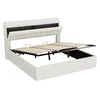 A white upholstered bed frame with the mattress support mechanism lifted to reveal storage space underneath. Anteprima dell’immagine prodotto