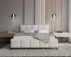 A modern bedroom with a cream bouclé bed as the focal point, flanked by minimalist nightstands and pendant lighting. Náhled obrázku produktu