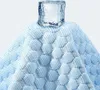 A close-up of a blue and white patterned fabric with a cube of ice on top. Náhľad obrázku produktu
