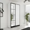 A modern wardrobe with mirrored doors and white panels, placed in a well-lit room with plants and a window view. Voir les images du produit