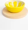 A yellow lemon-shaped bowl sits on a round wooden cutting board against a white background. Podgląd zdjęcia produktu