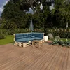 A pallet sofa with blue cushions and a small wooden table on a wooden deck, surrounded by greenery and trees. Náhľad obrázku produktu