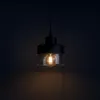 A black pendant light with a glass shade and an exposed bulb is shown against a dark background. Produktbild-Vorschau