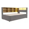 A gray upholstered daybed with a wooden bookshelf headboard, shown against a white background. Podgląd zdjęcia produktu