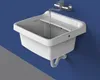 A white plastic sink with a faucet running water into it, mounted on a blue wall. Náhled obrázku produktu