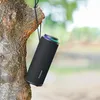 A black Tronsmart T8 outdoor speaker is hanging from a tree branch in a natural outdoor setting. Náhľad obrázku produktu