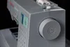 A close-up shot of the side and top of a gray sewing machine, focusing on the control panel and the handwheel. Anteprima dell’immagine prodotto