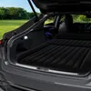 An inflatable mattress is laid out in the open trunk of a car, parked in a grassy field with trees in the background. Náhľad obrázku produktu