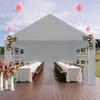 A party tent set up with tables and chairs, decorated with flowers and balloons. Voir les images du produit