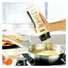 A hand holding a batter dispenser over a frying pan, making pancakes. Produktbild-Vorschau
