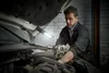 A mechanic is working on a car engine with a portable LED light. Anteprima dell’immagine prodotto