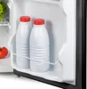 Inside view of a refrigerator door shelf with two white bottles with red caps and a tomato. Voir les images du produit