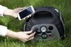 A person is using a portable power station to charge a smartphone and a flashlight in a grassy outdoor setting. Podgląd zdjęcia produktu