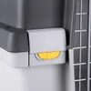 A close-up of a gray and white pet carrier with a yellow lock mechanism. Podgląd zdjęcia produktu