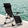 A black zero gravity chair is placed on a white surface next to a body of water. Produktbild-Vorschau