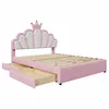A pink upholstered bed frame with a shell-shaped headboard adorned with a crown, shown with two drawers pulled out. Anteprima dell’immagine prodotto